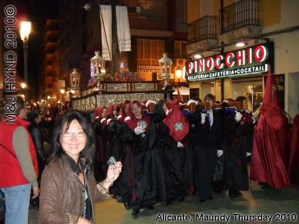 spain Alicante, Semana Santa Holy Week, Maundy Thursday procession, Brotherhood long pointed red hood, long capes, paso-bearers religious floats, silver Jesus's sculpture, somber march