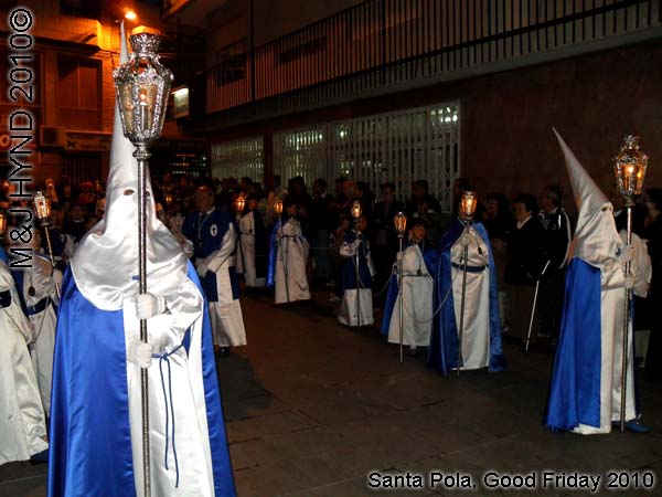  spain Santa Pola, Semana Santa Holy Week, Good Friday procession, Brotherhood long pointed white hoods, long capes carry lamps on poles 