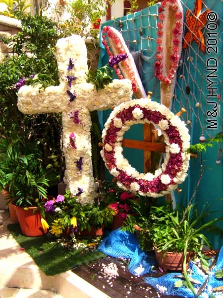 cross+wreath: spain, Alicante Santa Cruz Fiesta, festive buntings, white fresh flowers decorated Crosses white purple wreath, little pink roses paddles, aquatic scene starfish fishing nets