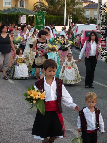 parade of kids: spain valverde fiesta La Virgen de Santa Ana, children adults partipants traditional long ballgown lace mantilla, Damas of Fiesta, floral offering procession