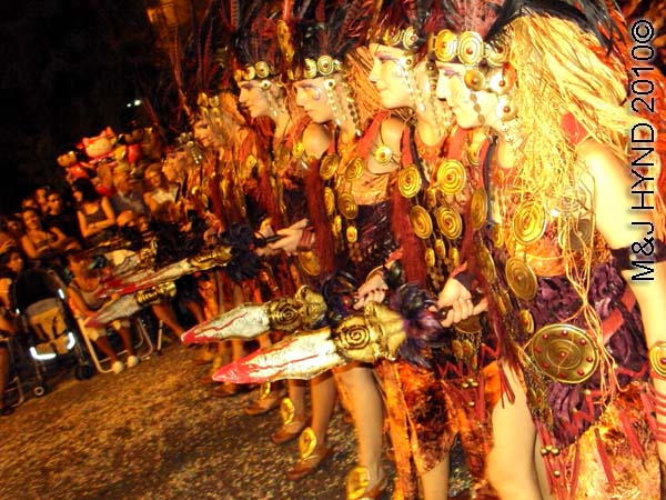 parade – red+gold: spain Santa Pola Annual Fiesta, procession Moorish warrior women, carry mock spears, confetti