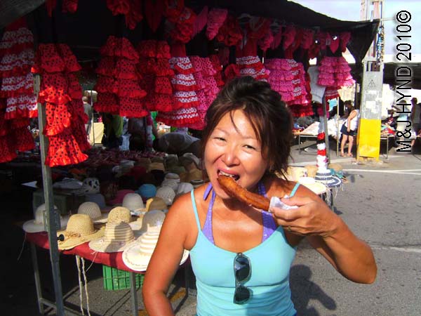 spain Santa Pola Saturday market enjoying sugar-covered churro, childrens flamenco dresses