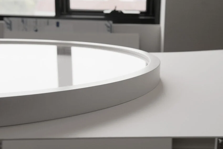 Round frame 120cm square in smooth white lacquer with acrylic glazing and space between the acrylic and art piece for protection.