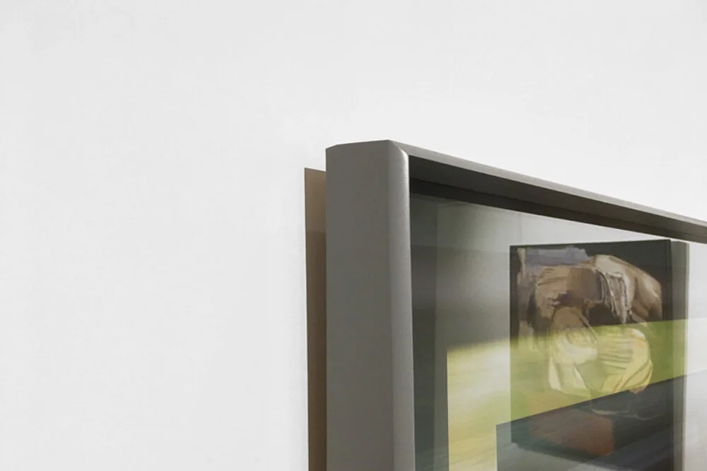 A mid grey opaque frame with an ultra deep set rebate to set back the glazing and slight curve at the front leading to a sharp front edge.