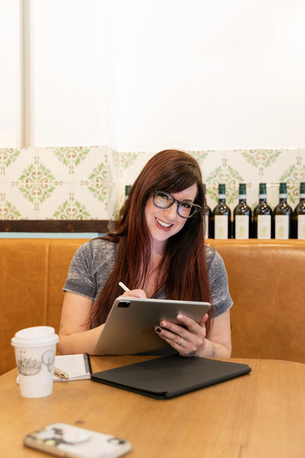 Perth branding & logo designer, Joanne Tapodi with her iPad in a local cafe.