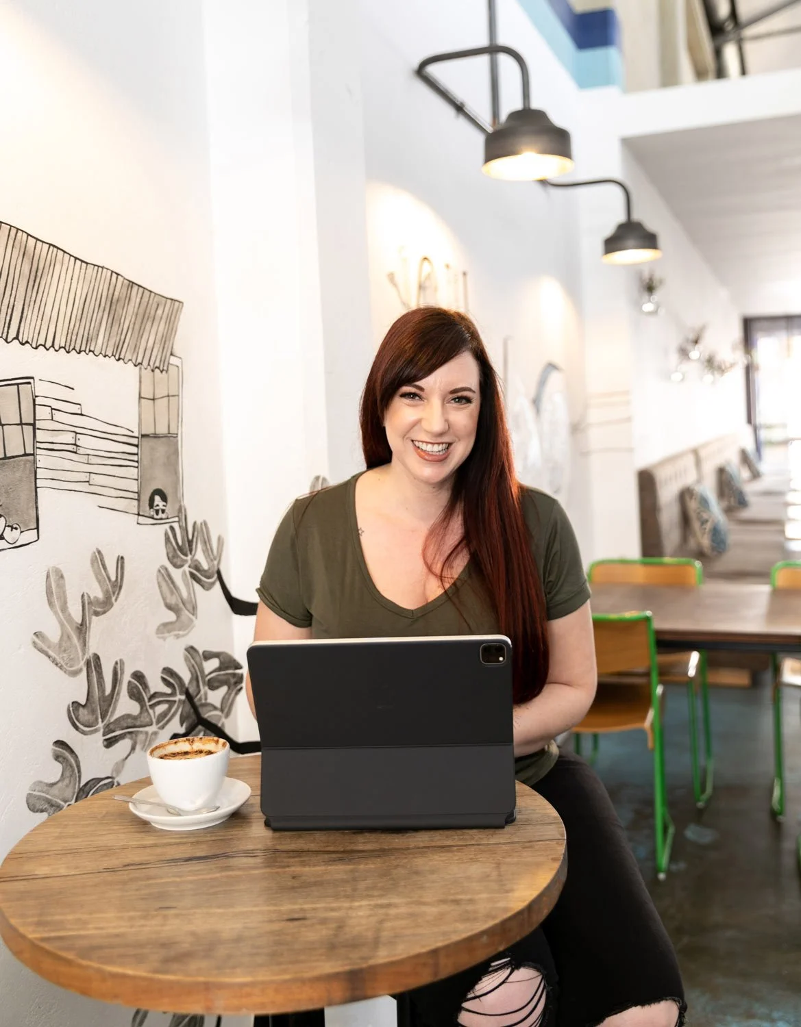 Joanne Tapodi, Perth Brand Strategist and Squarespace Website Designer, working with Squarespace on iPad in a Perth cafe