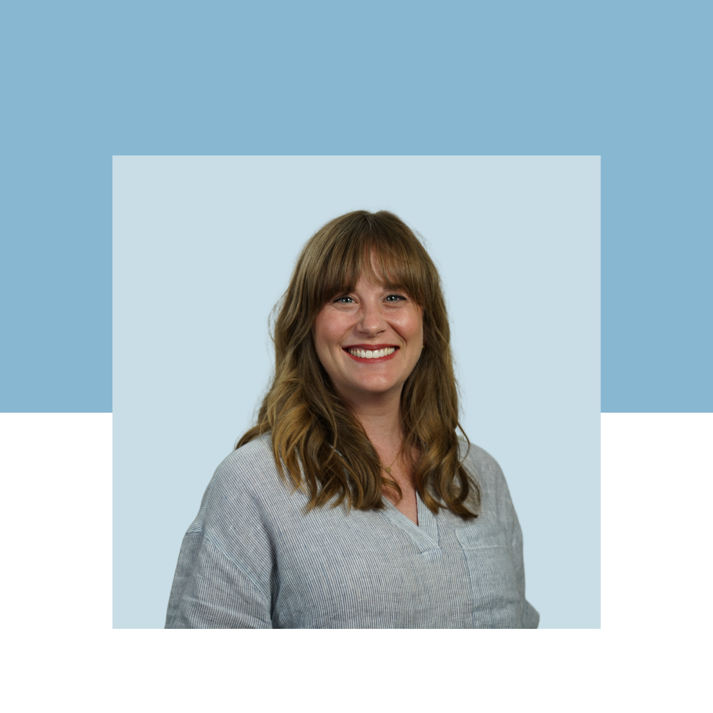 Woman smiles with shoulder-length brown hair with a blue denim shirt and light blue background.