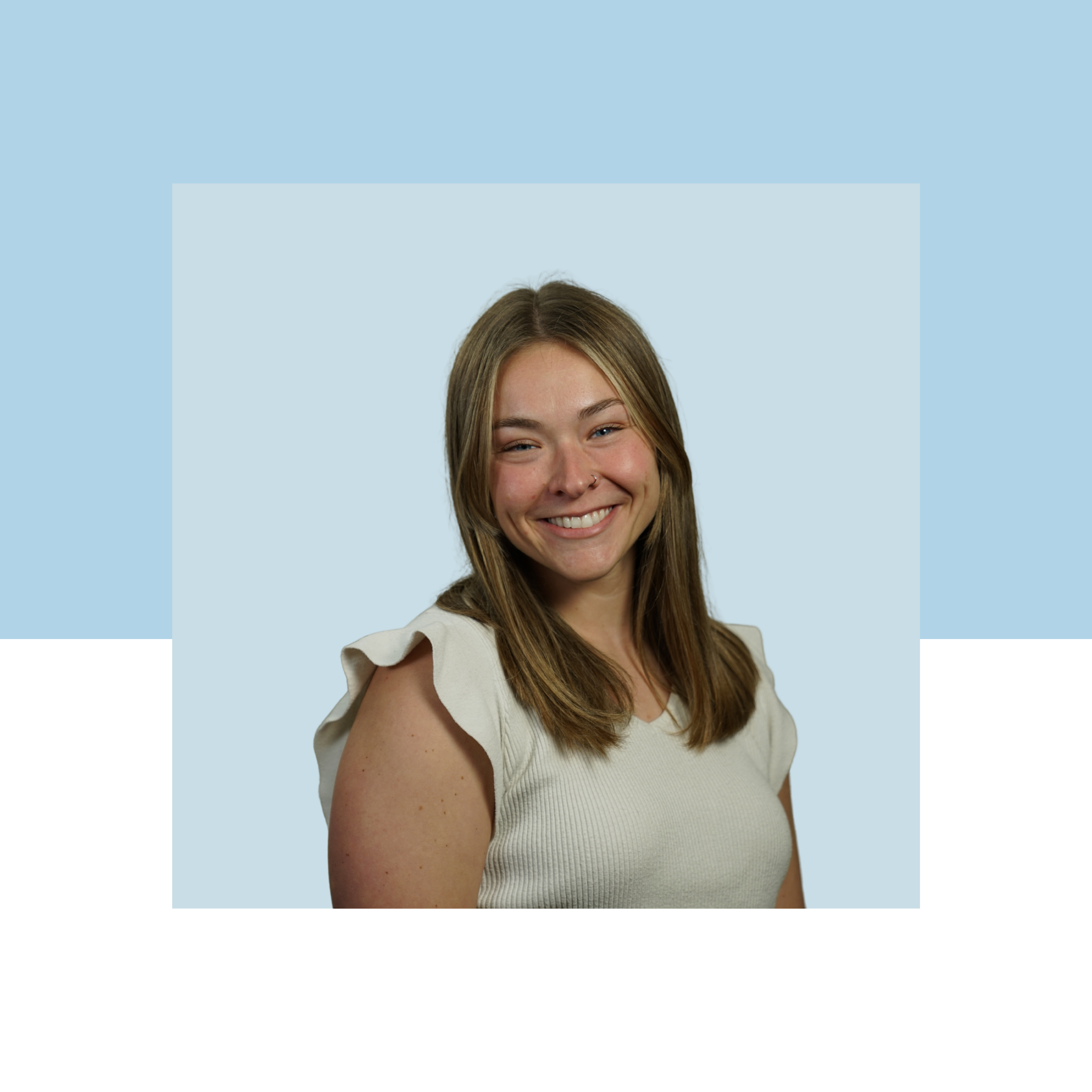 Woman with brown shoulder-length hair smiling with a blue background.