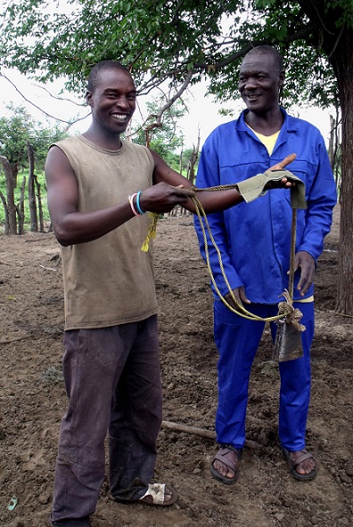 A Happy Cattle Owner proudly displays our cattle tracker unit with our Project Assistant Chris (left)
