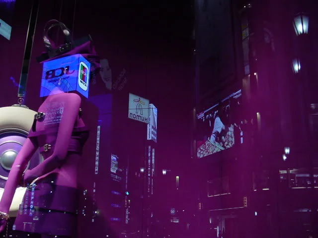 Tokyo's Akihabara district at night; glowing signs and enormous screens are reflected in shop windowsTokyo, Japan2006