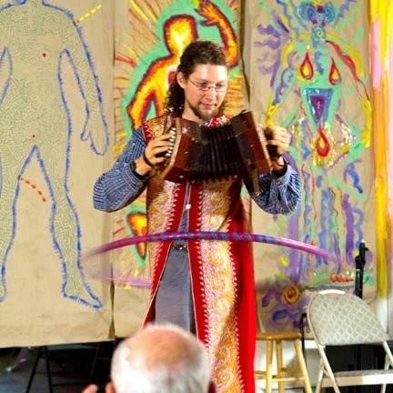 Concertina player in front of art
