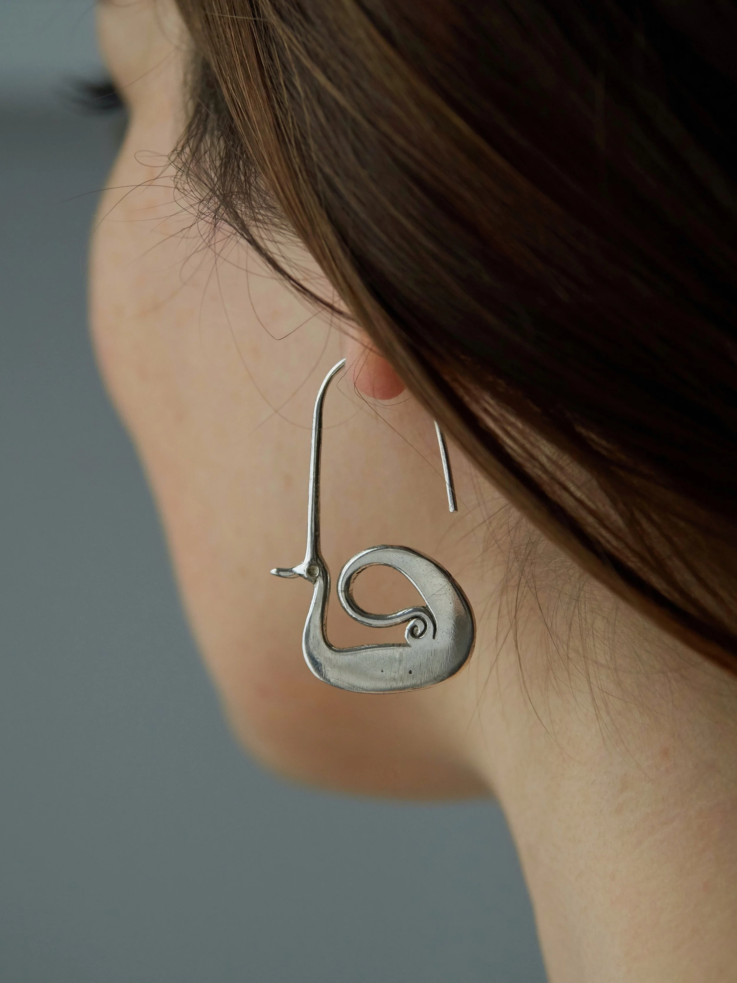 Majestic bird earrings by Elisabeth Riveiro in silver-plated bronze, sculptural artisan jewellery worn on ear