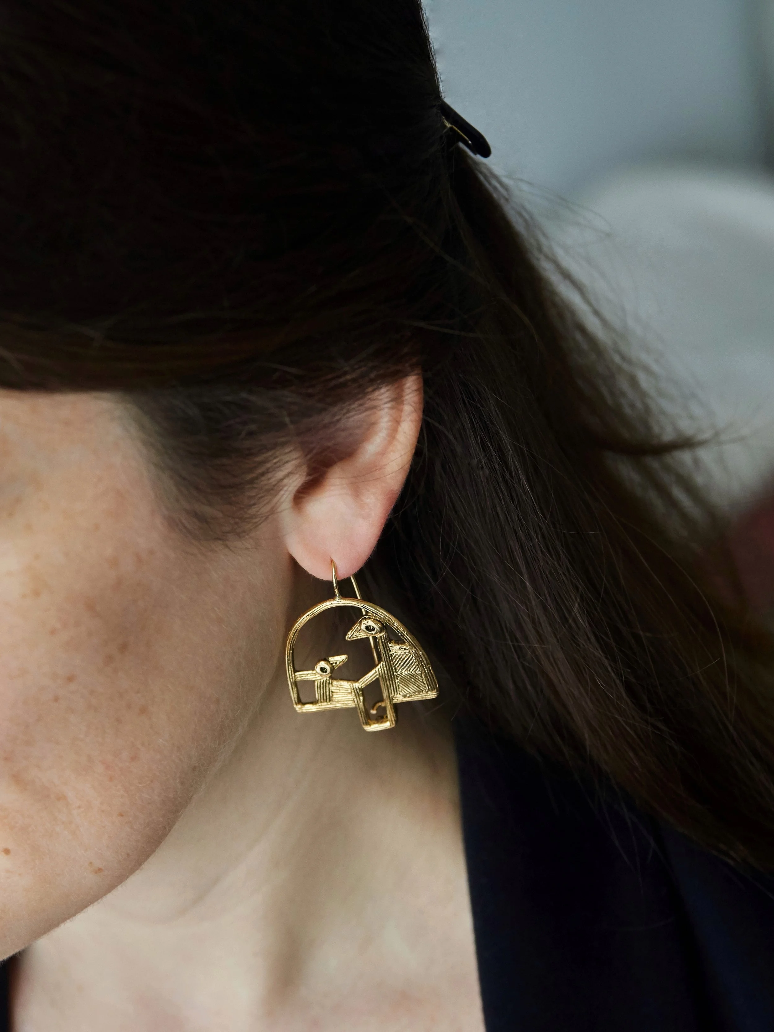 Elisabeth Riveiro BALANÇOIRE bird earrings in gold-plated bronze worn on model, handcrafted in Paris using traditional lost-wax casting, available at AMBART Palma de Mallorca