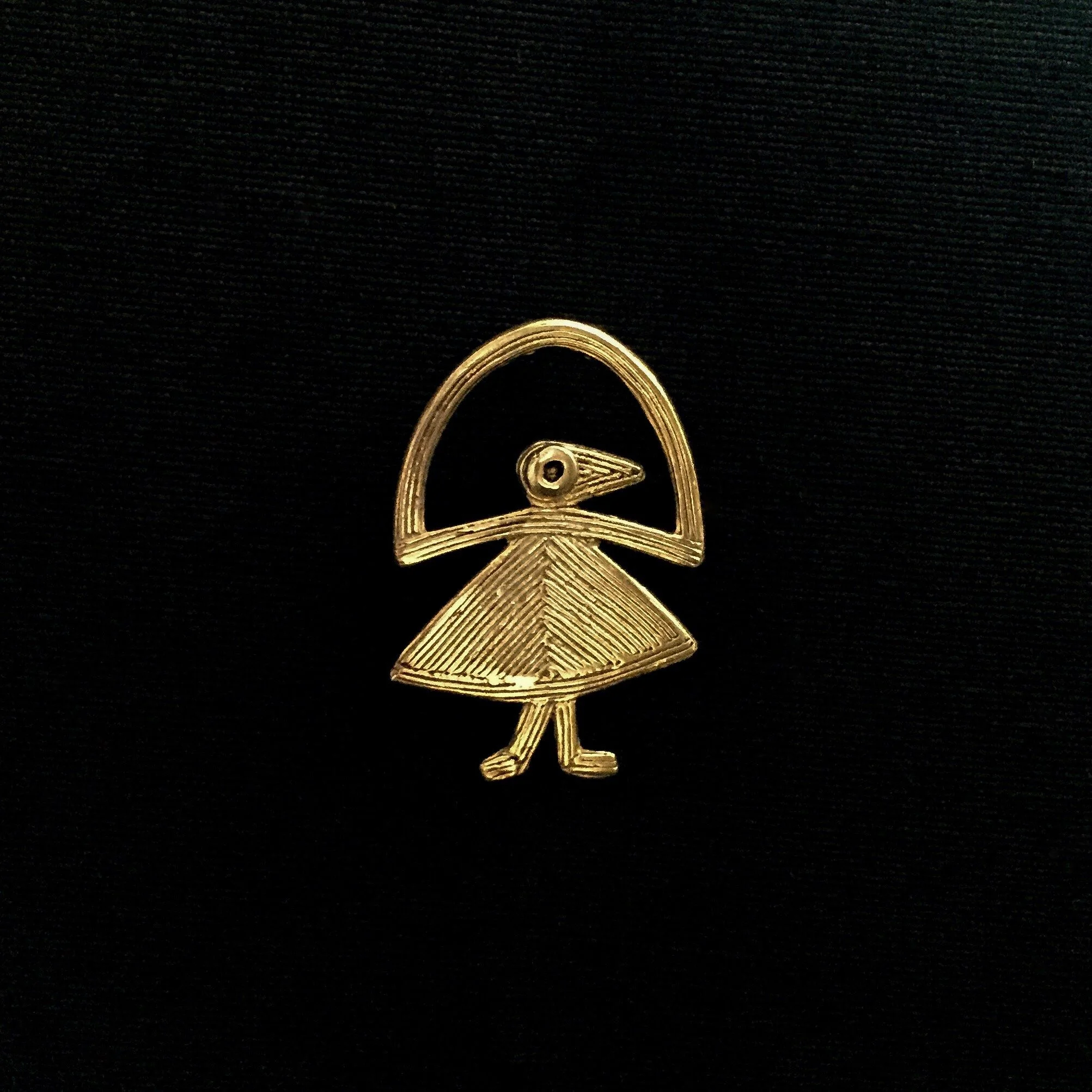 “Elastis” fibula brooch pin by Elisabeth Riveiro in gold-plated bronze, stylised dancing bird motif cast using the traditional lost-wax technique.
