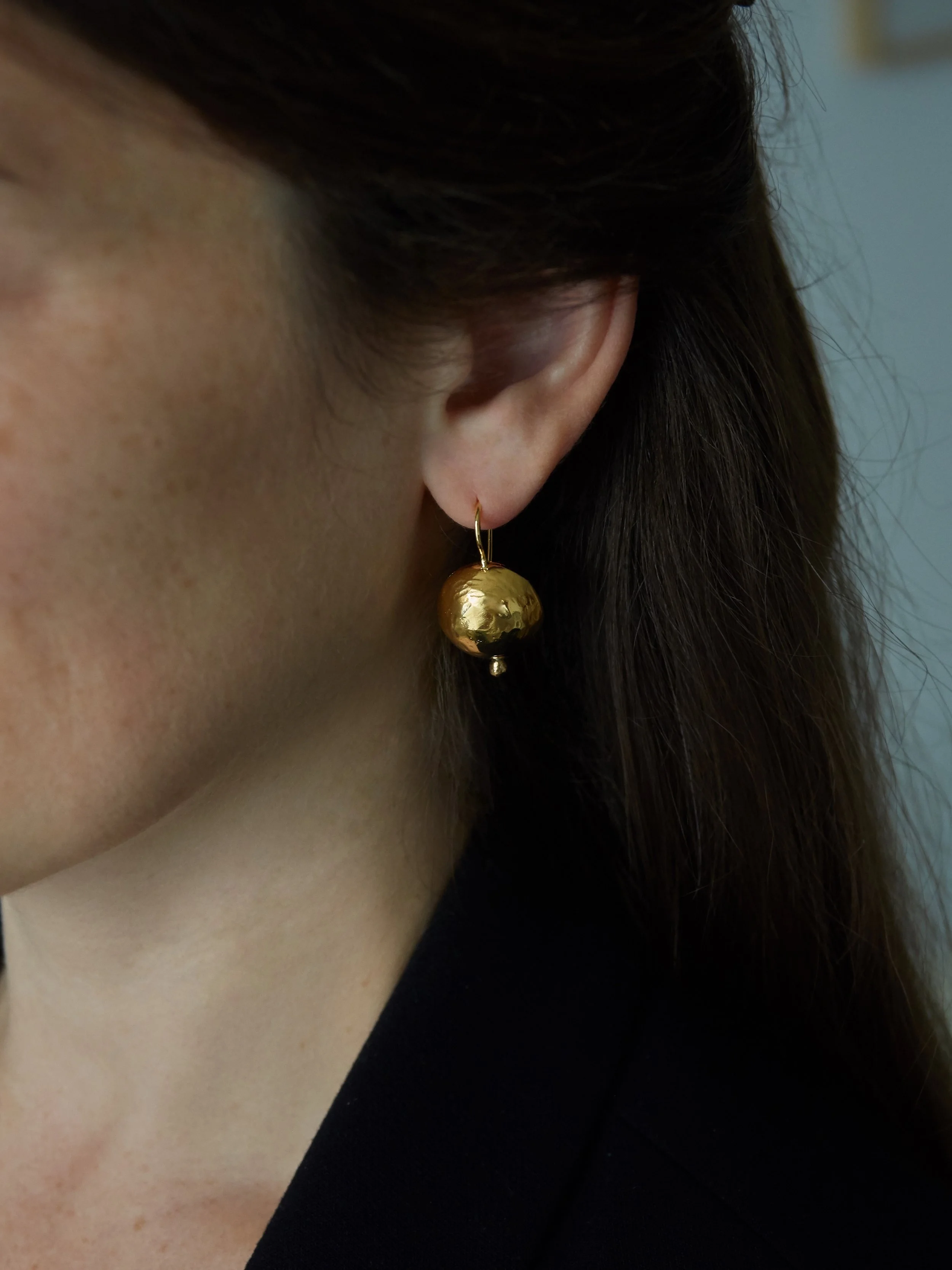 GRANDES SPHÈRES gold-plated bronze drop earring by Elisabeth Riveiro, featuring a hammered spherical pendant.