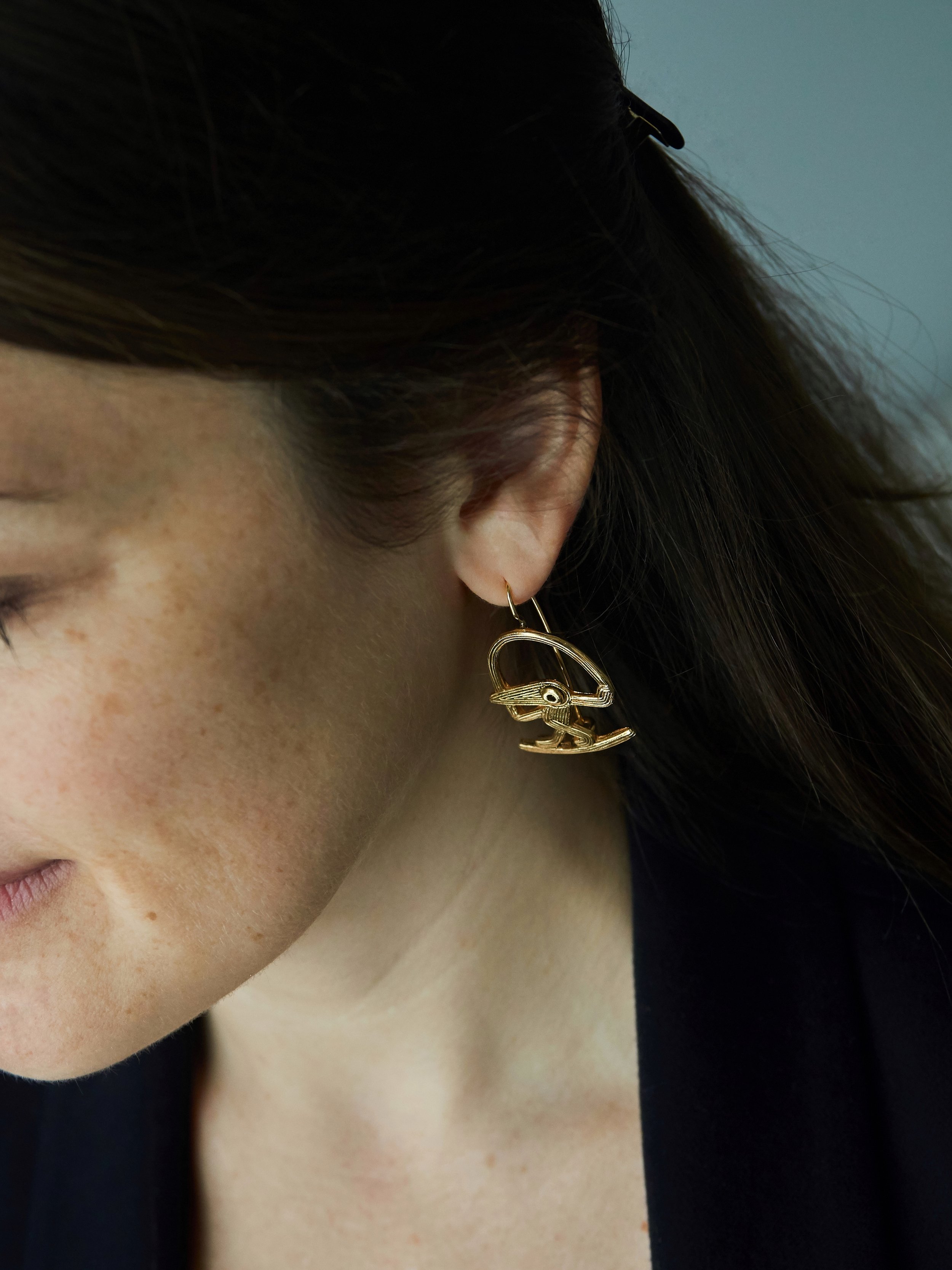 Cordeli bird earrings in gold-plated bronze by Elisabeth Riveiro, handcrafted in Paris using the lost-wax casting technique, worn on model – AMBART Palma de Mallorca.