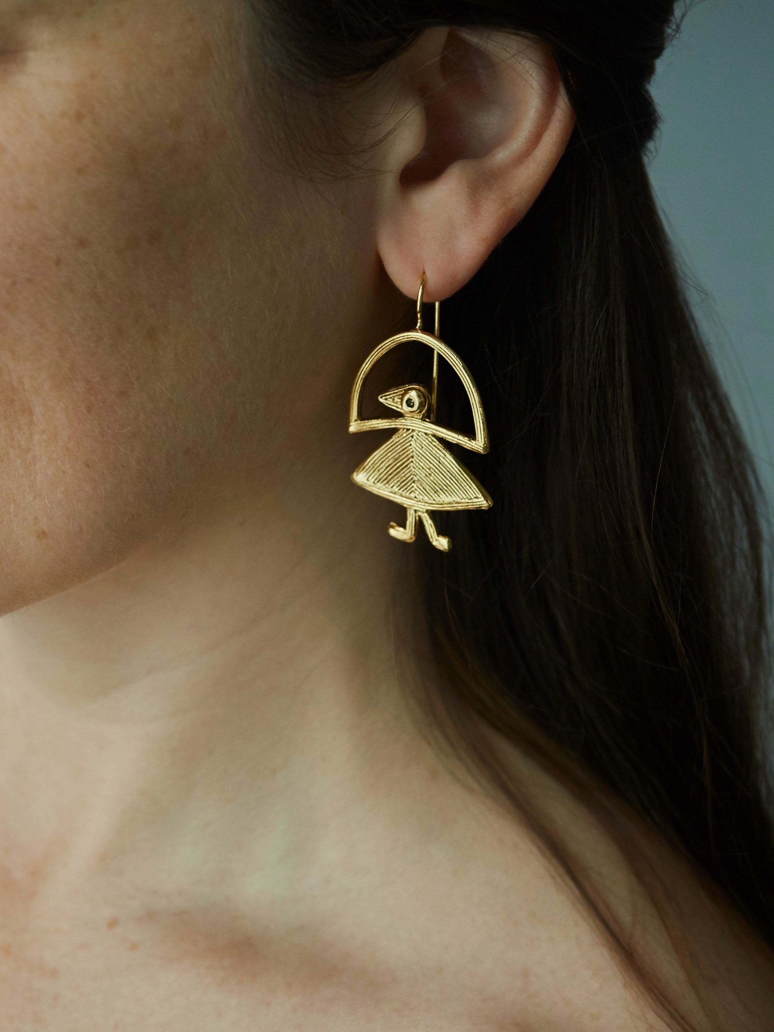 Elastis bird earrings in gold-plated bronze by Elisabeth Riveiro, sculptural handcrafted jewellery worn – AMBART Palma.