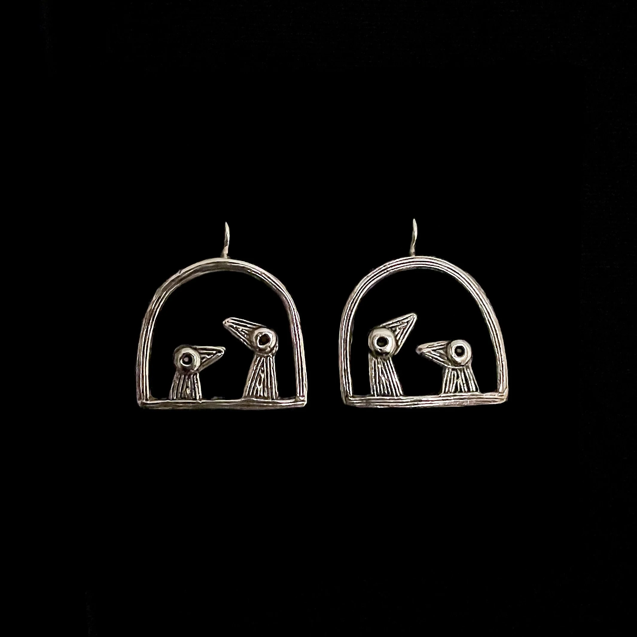 “Père et Fils” bird earrings in silver-plated bronze by Elisabeth Riveiro, sculptural design, front view on black background