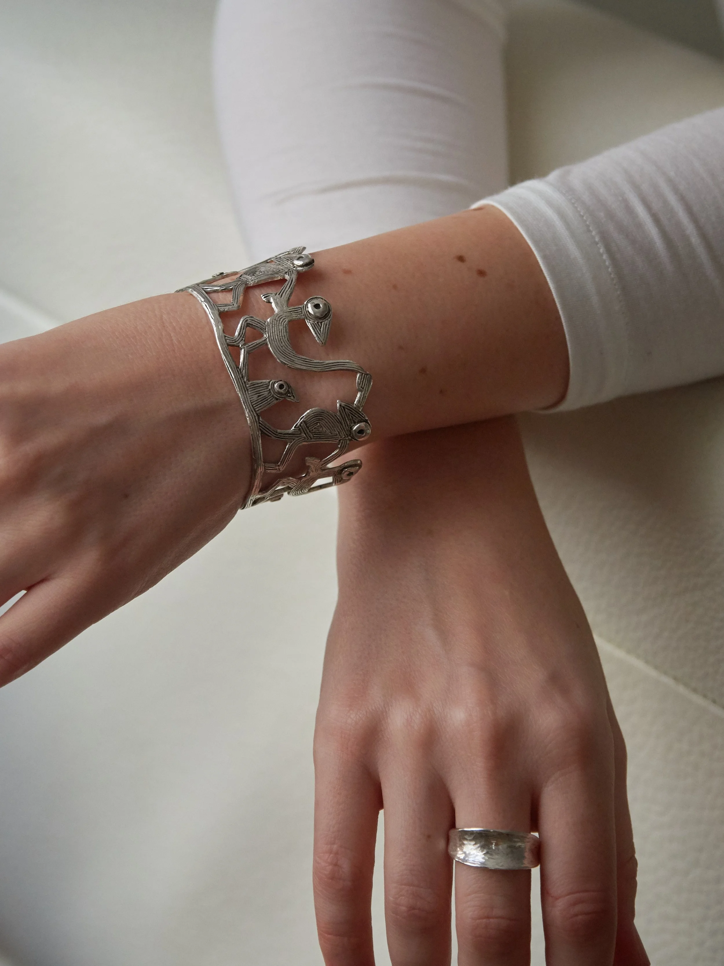 Farandole cuff bracelet by Elisabeth Riveiro in silver-plated bronze, sculptural artisan jewellery inspired by ritual bird dance.