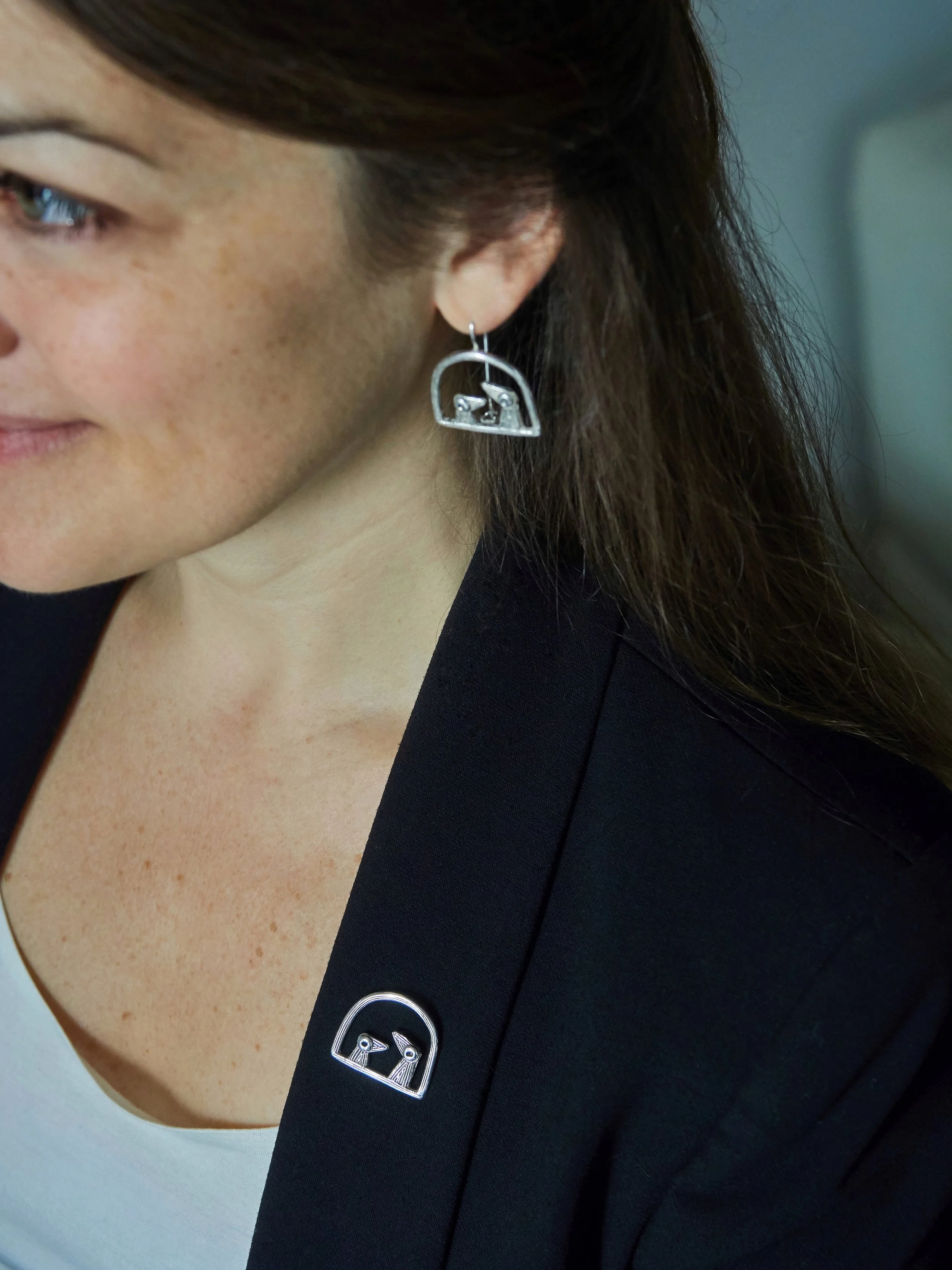 Elisabeth Riveiro “Père et Fils” bird fibula brooch in silver-plated bronze, worn on a blazer, handcrafted in Paris using traditional lost-wax casting.