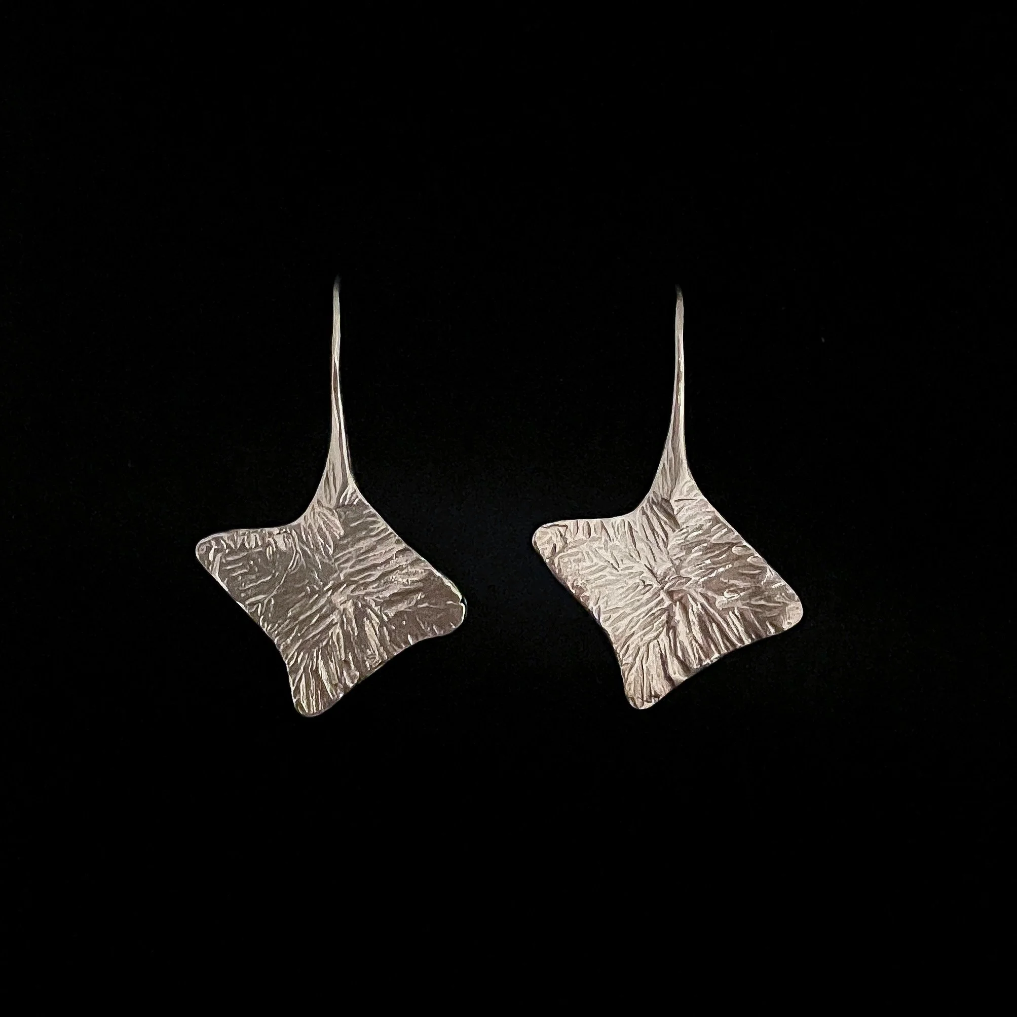 Palmyre silver-plated bronze earrings by Elisabeth Riveiro Paris. Sculptural organic drop earrings featuring an elongated hook and richly textured, radiating reliefs. Available at AMBART Mallorca.