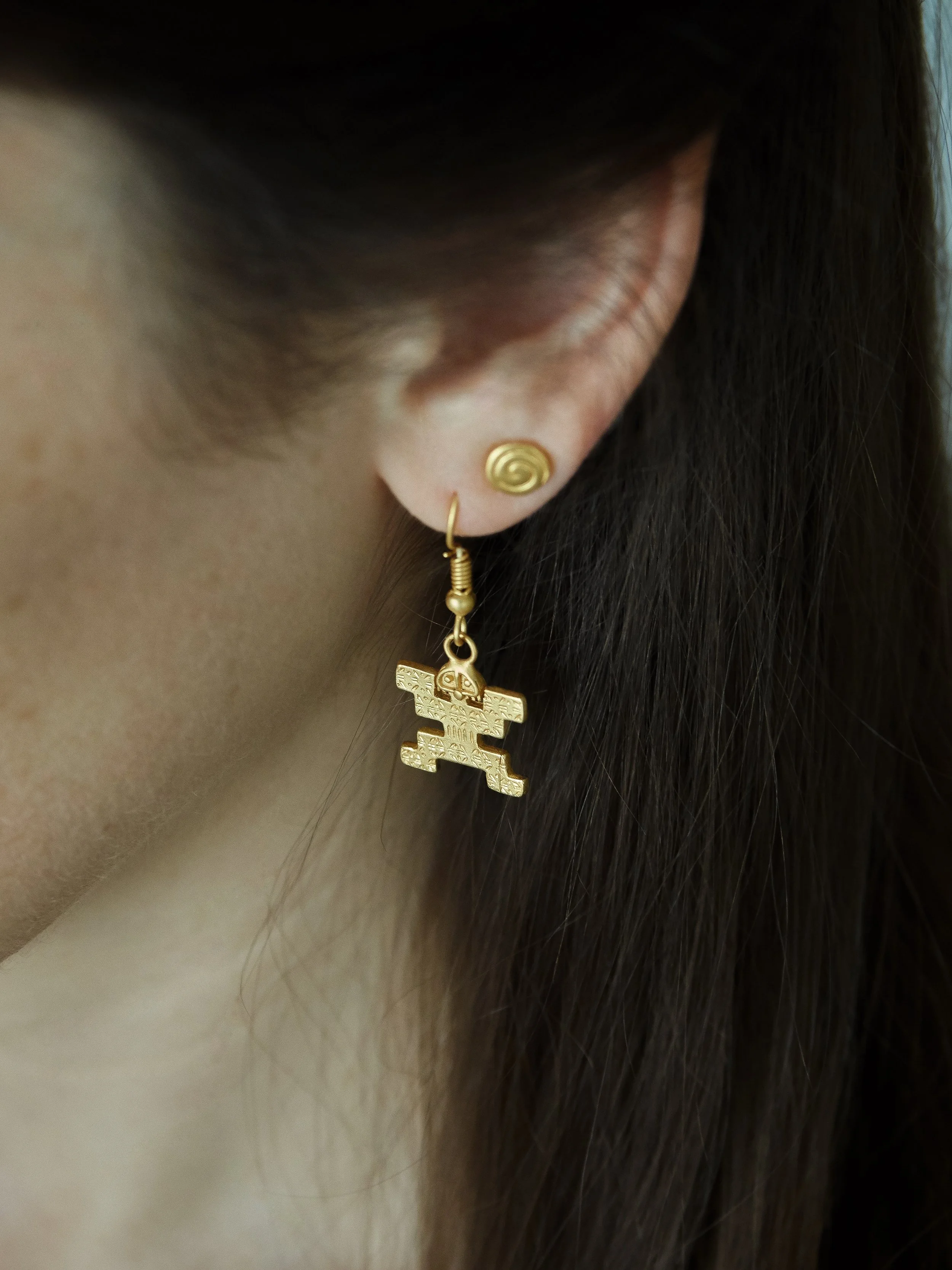 Gold-plated Tolima jaguar-man earring from Galeria Eldorado, inspired by an ancient pre-Columbian Colombian goldwork figure.