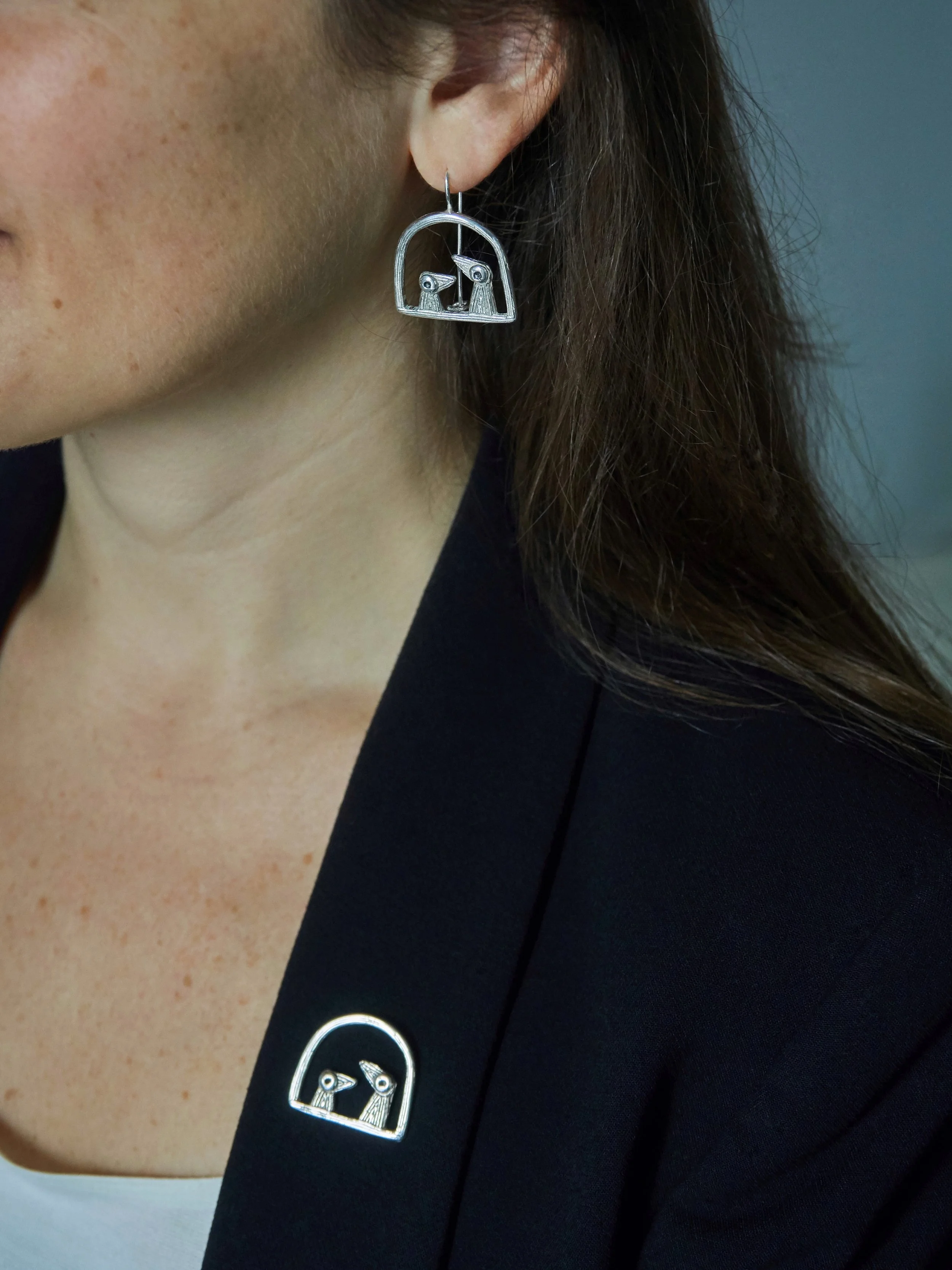 Handcrafted “Père et Fils” bird earrings in silver-plated bronze by Elisabeth Riveiro, worn with matching fibula brooch, AMBART Palma de Mallorca