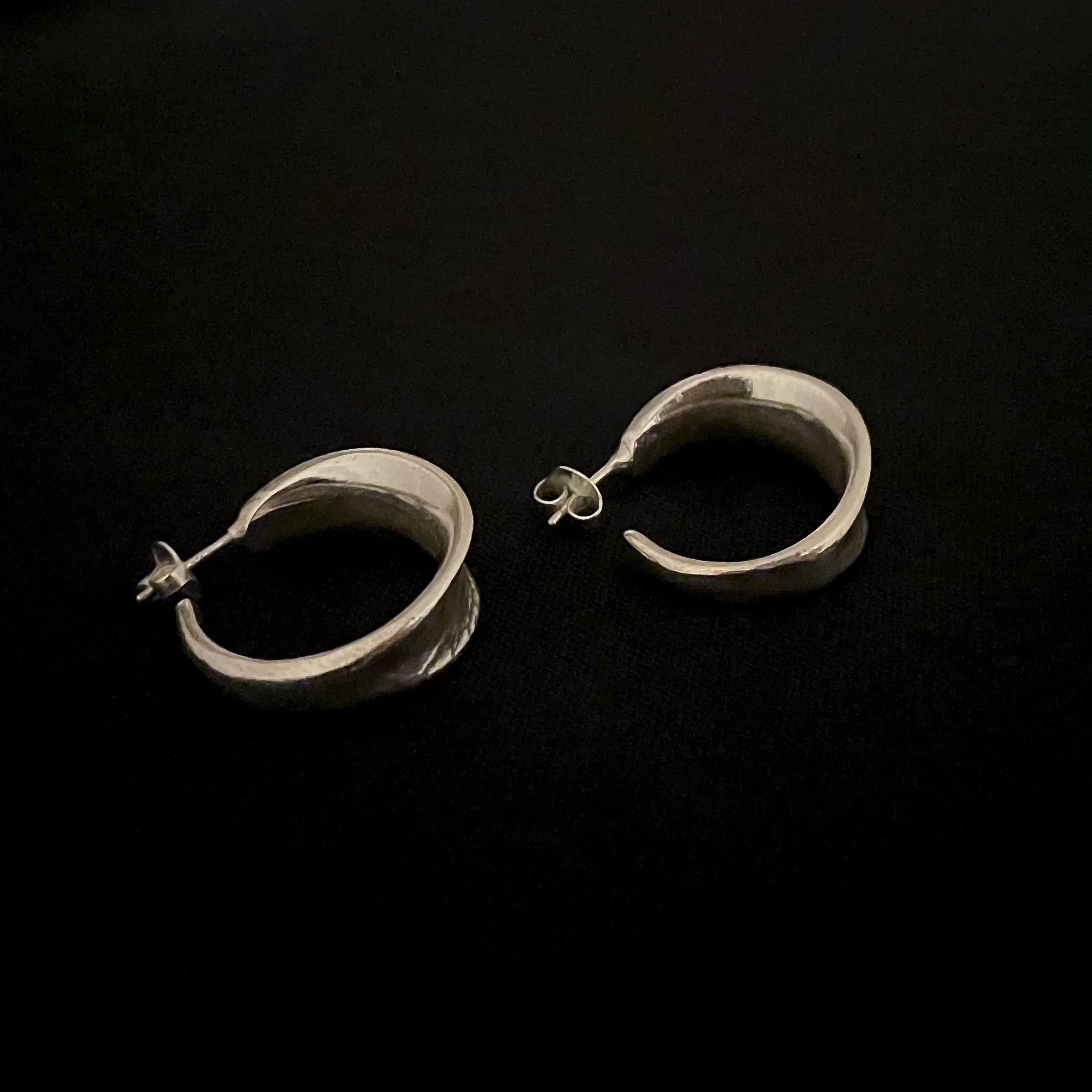 Back view of the Petit Val silver-plated bronze hoop earrings by Elisabeth Riveiro, showing their open sculptural shape, ear posts and butterfly backs.