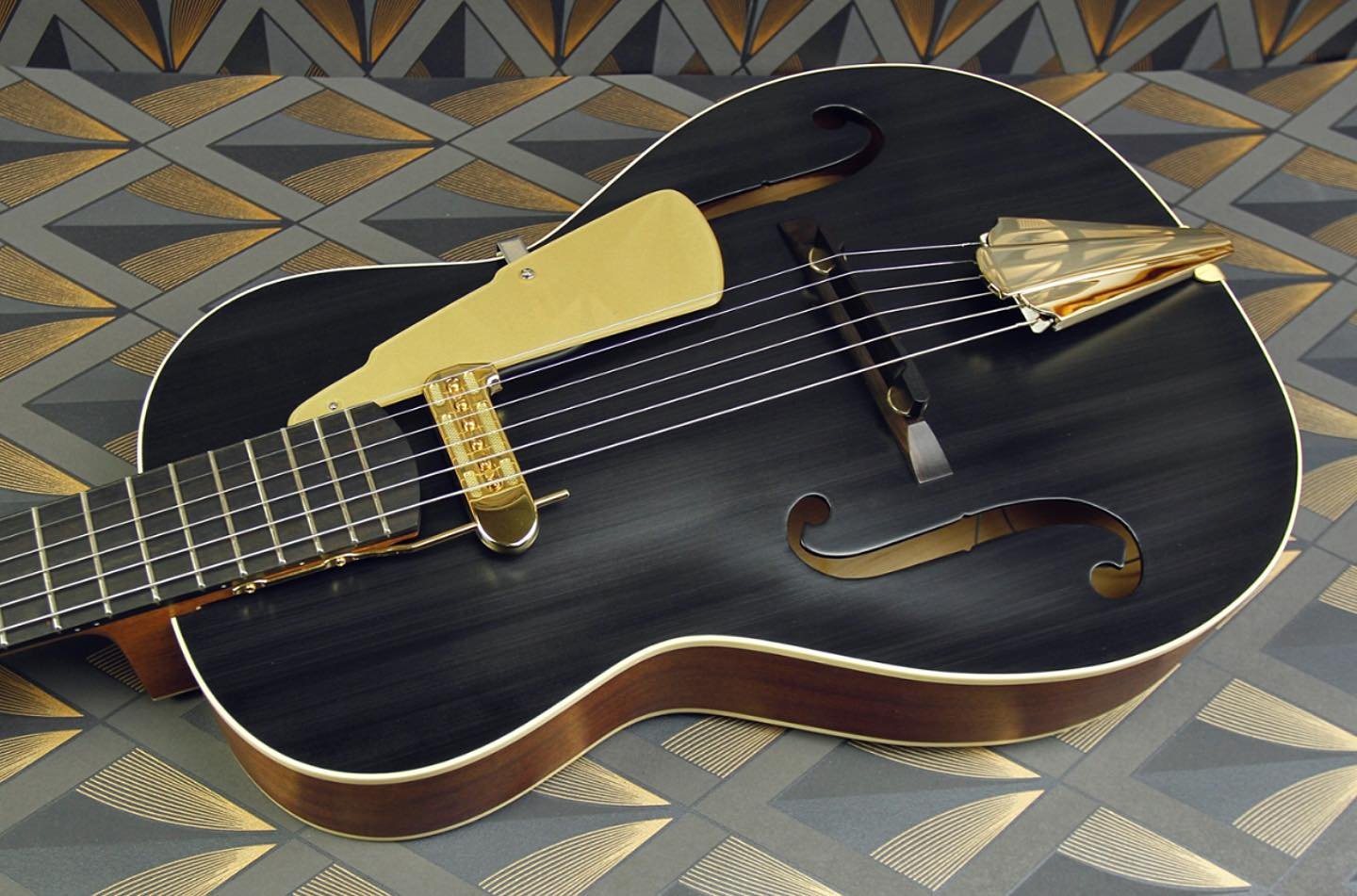 Here&rsquo;s a final reclining shot of the latest Rosetta Model 2 - In brushed satin finish, this is a spruce and sapele guitar with a gold plated Art Deco tailpiece and back painted acrylic pickguard. The guitar explores a new lamination formula for
