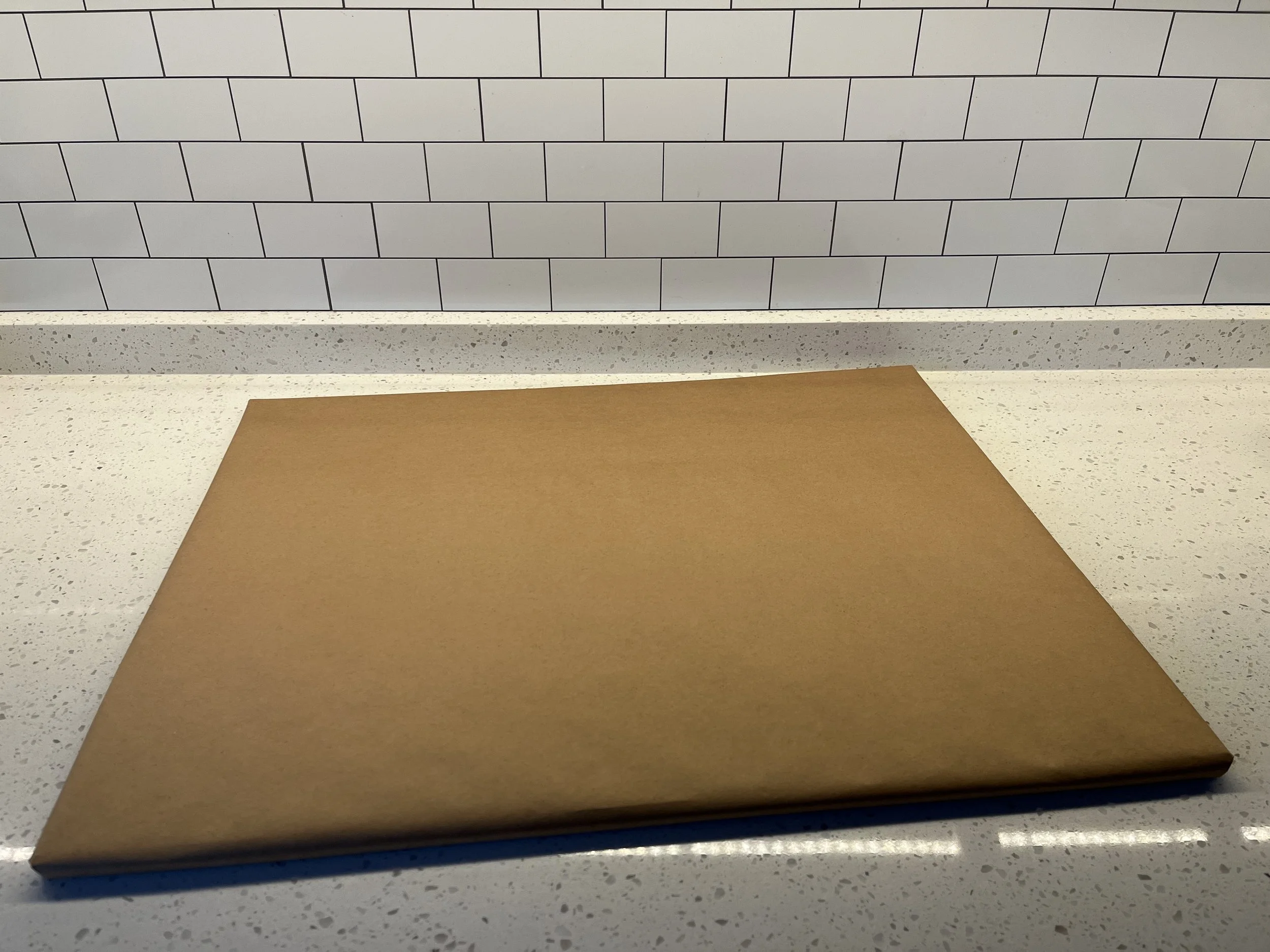 Cover your plywood with kraft paper. This is the surface the cake will sit on.