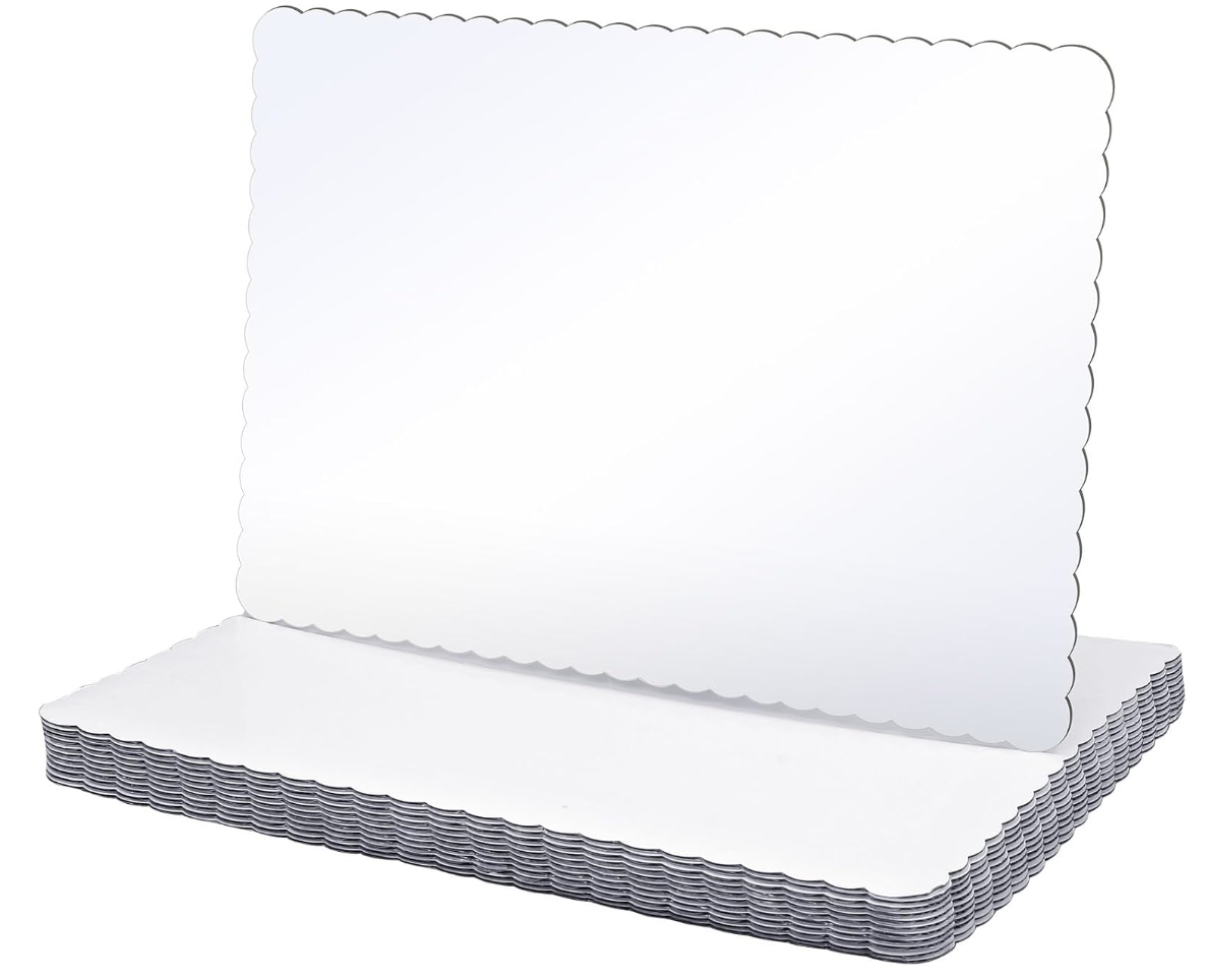 Picture of a white scalloped edge cardboard base you can buy to build a DIY cake on at home.