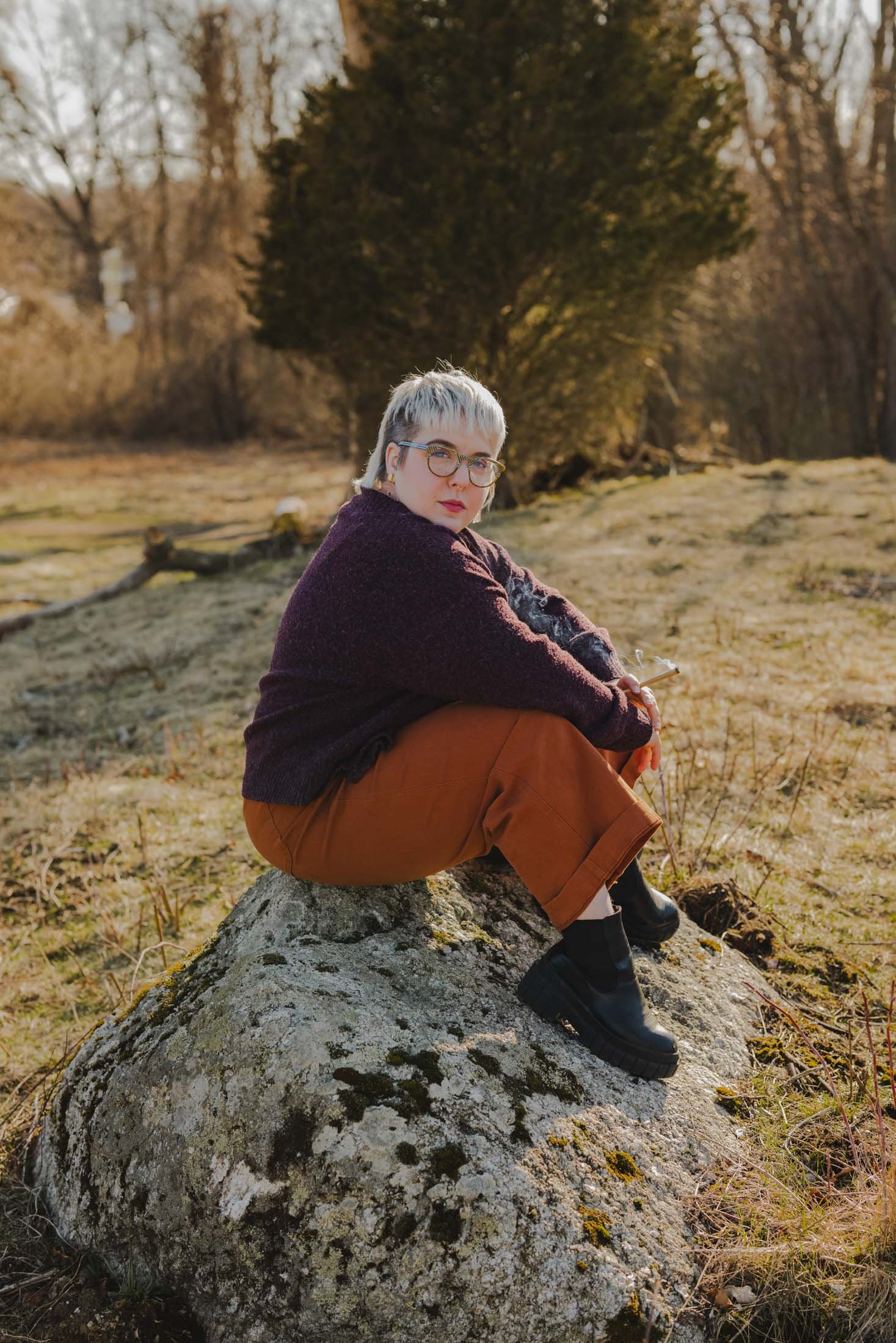 Amanda sitting on a rock with her arms resting over her knees