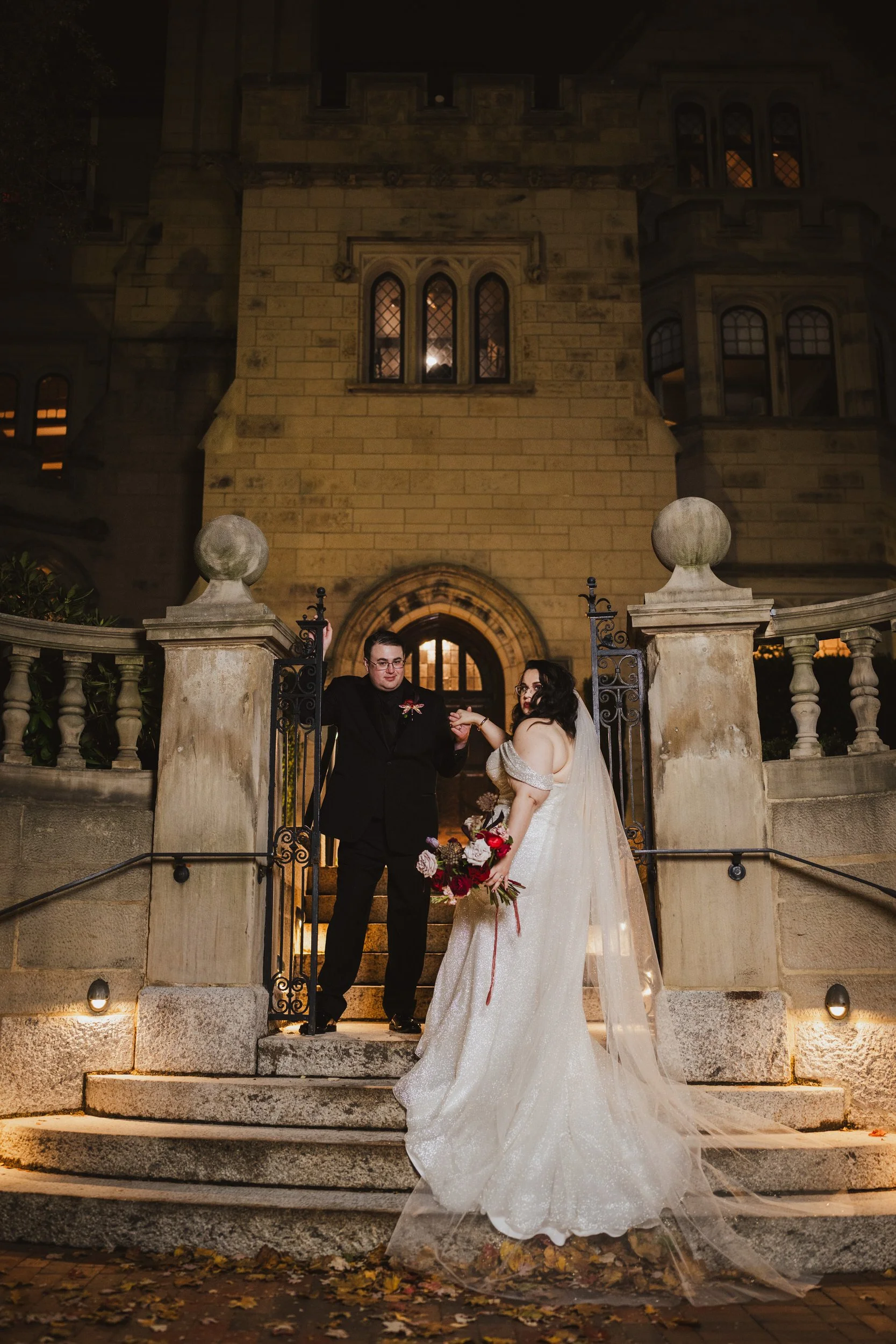 A newlywed holding their hand out to their partner as they walk up stairs