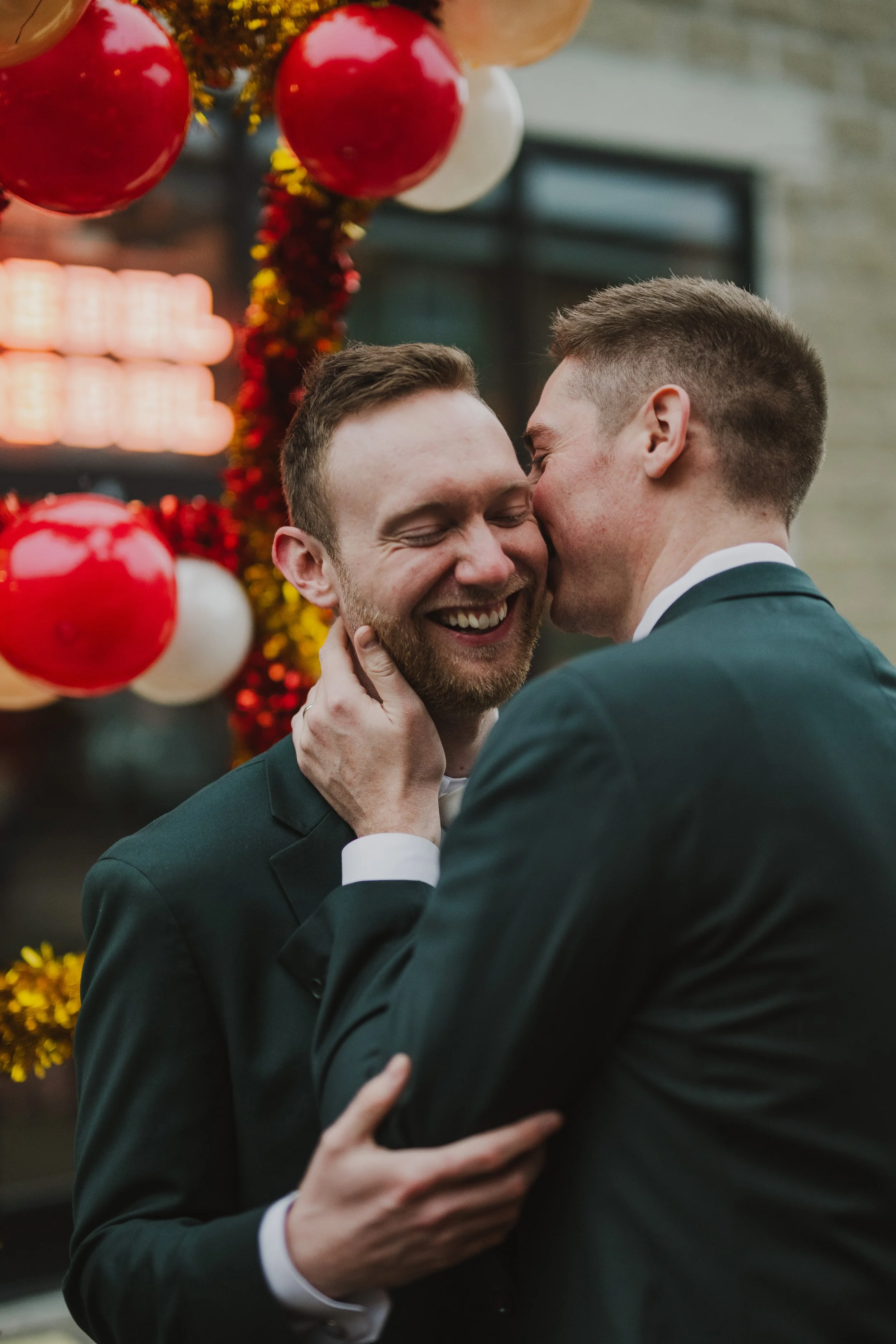 A man kisses their husband's cheek just after saying "I Do" at Dearly Studio in Bow Market