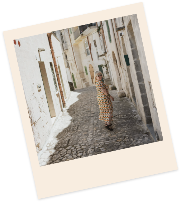 Amanda looking over her shoulder as she walks down a small alley