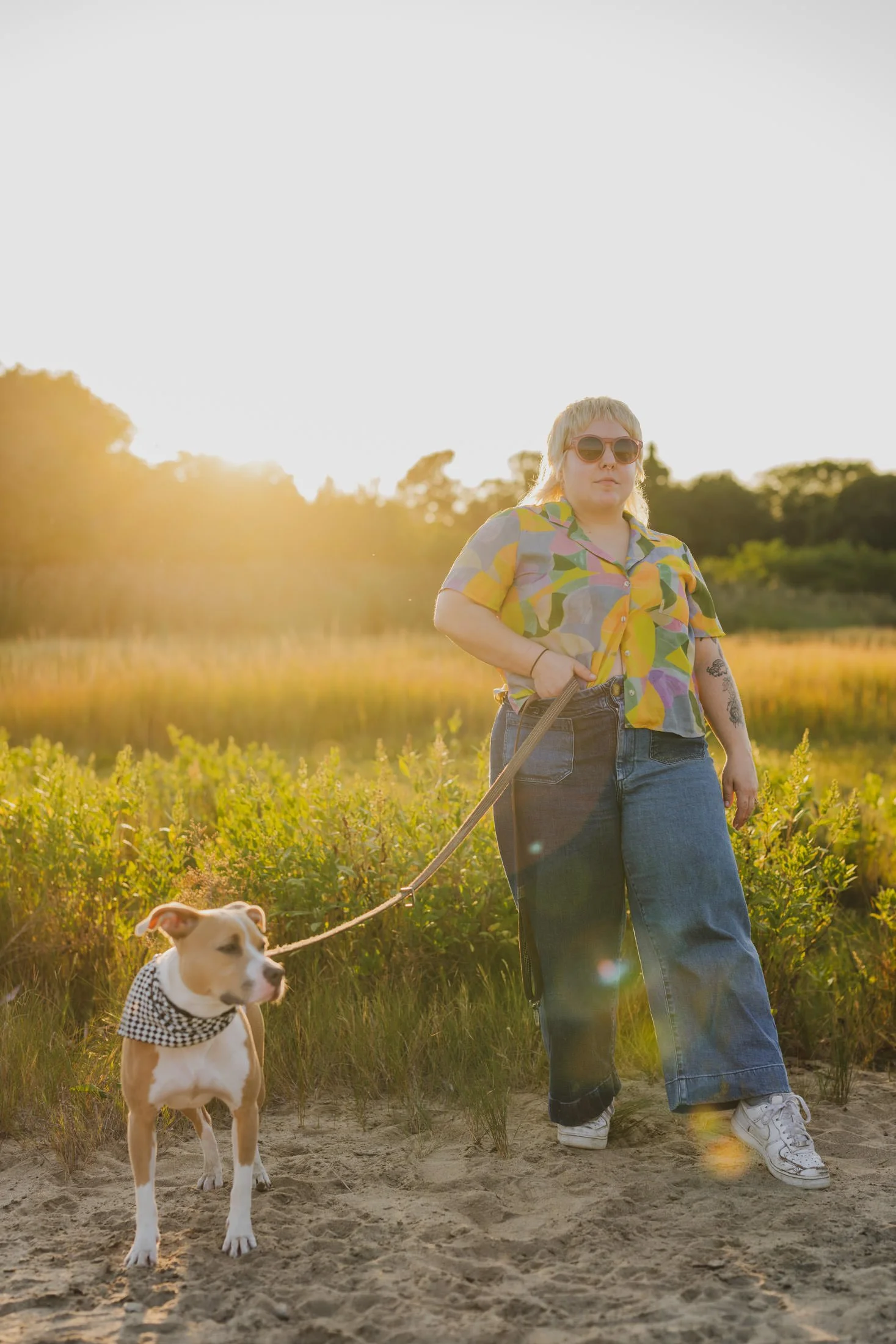 Amanda standing in a field with her dog next to her