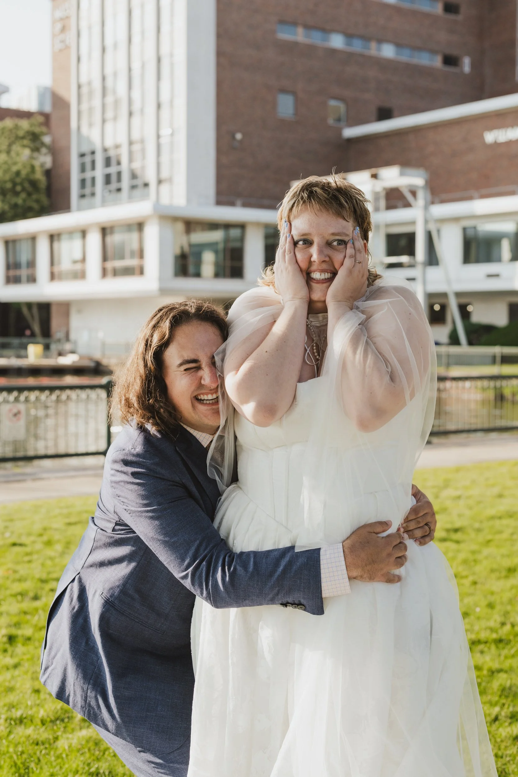 A newlywed hugging their partner's waist while they laugh