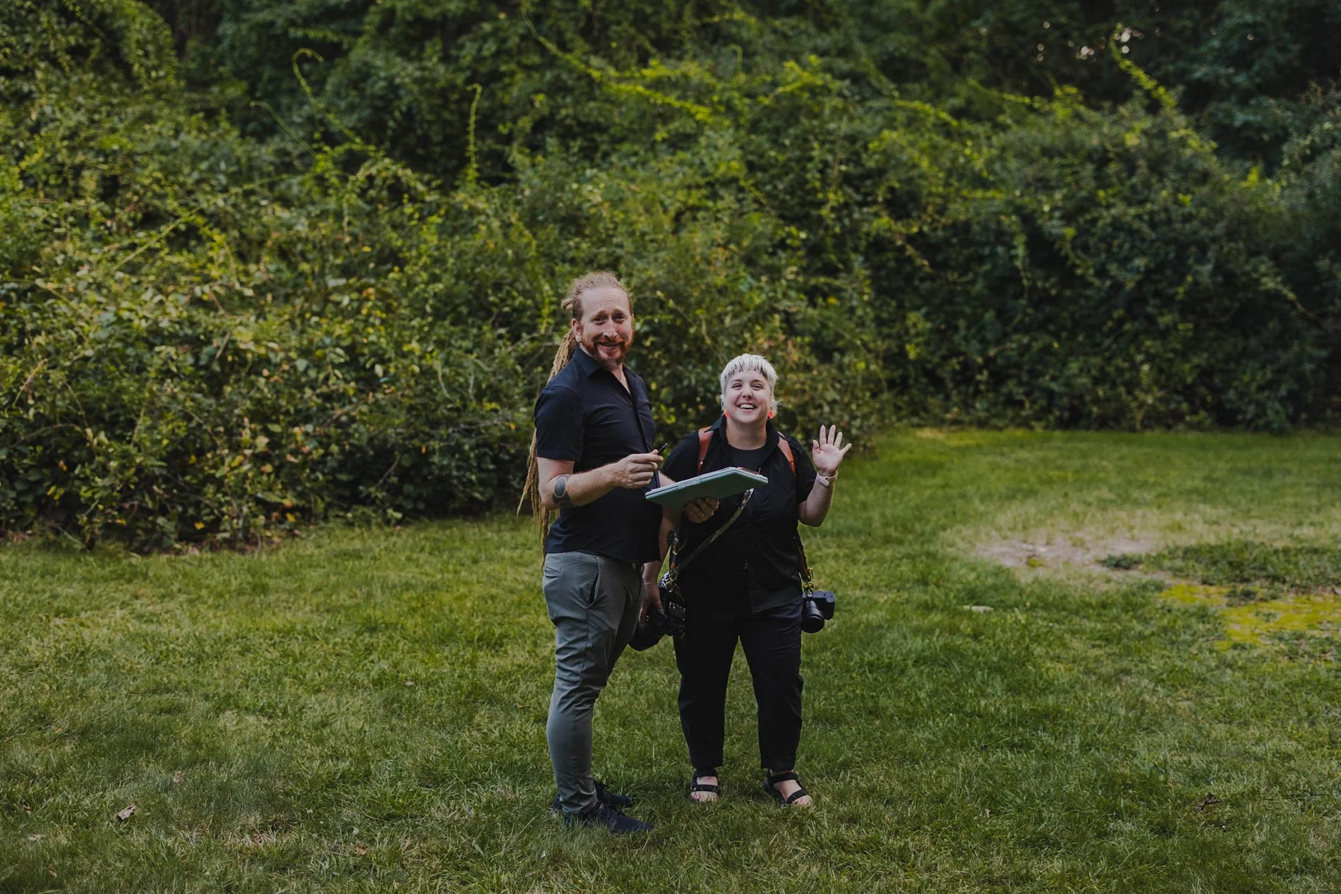 Amanda and Mike standing in a grassy area smiling and laughing