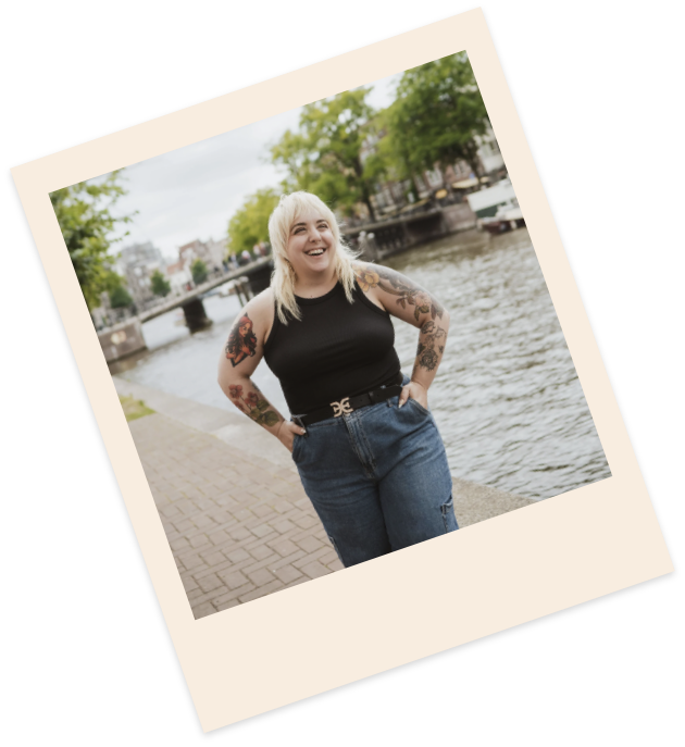 Amanda standing by a river smiling with her hands in her pockets