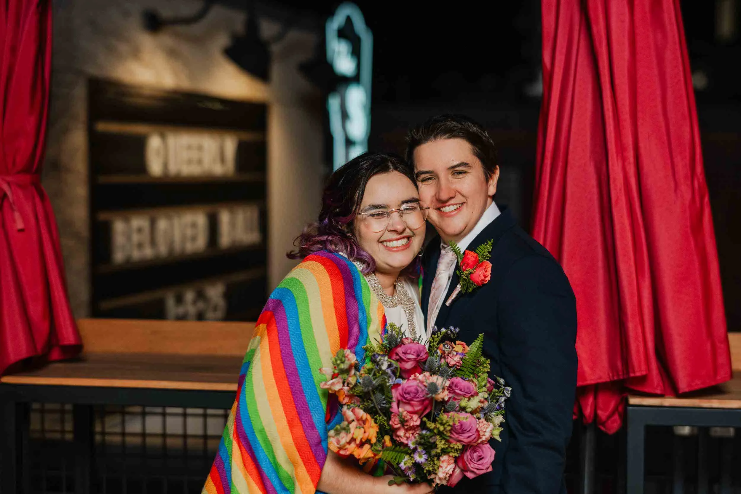 A newlywed couple smiling as they lean their faces together