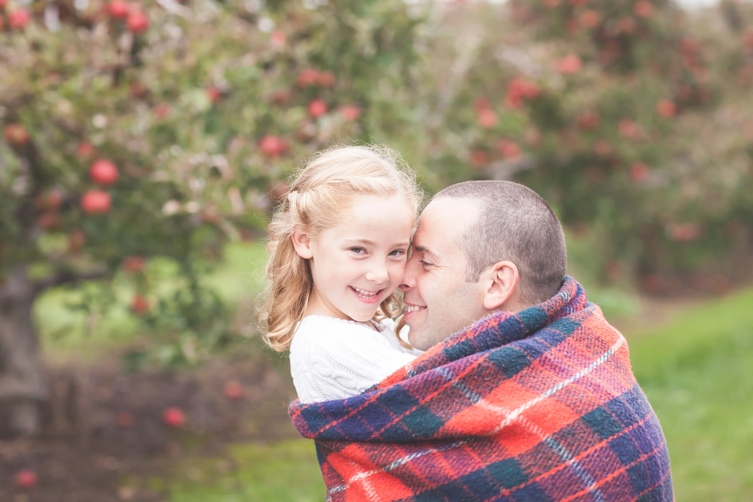 Father hugging daughter at the apple orchard