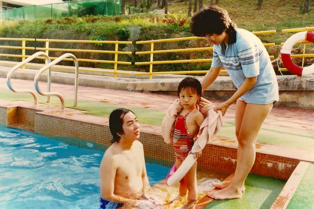 Child playing in swimming pool with parents - Sunday Kind of Love