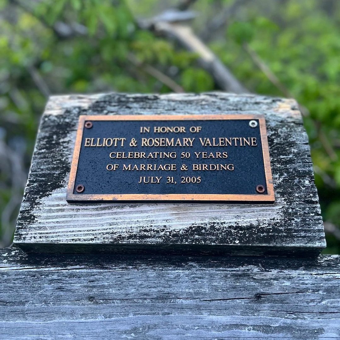 Plaque on a built-in boardwalk bench reads, "In honor of Elliott and Rosemary Valentine, Celebrating 50 years of marriage and birding, July 31 2005."