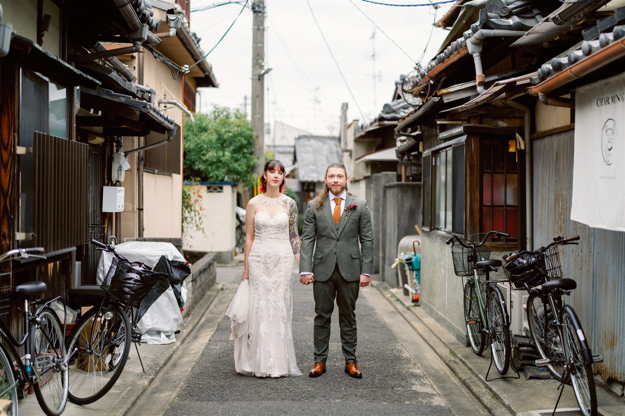 Couple pose in their wedding attire during their elopement in the streets of Kyoto. 