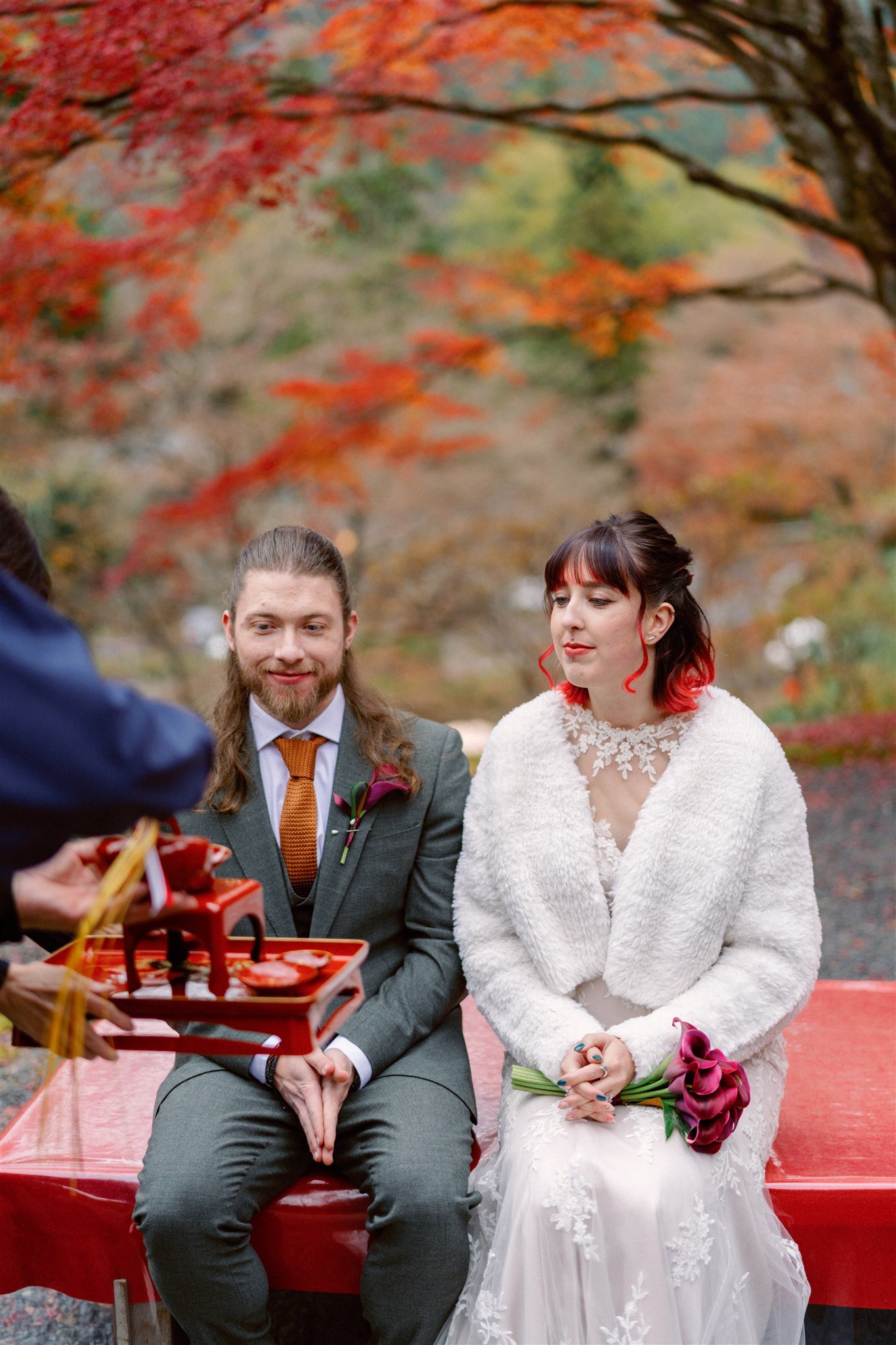 Couple have a celebratory tea ceremony after their elopement at a Japanese garden. 
