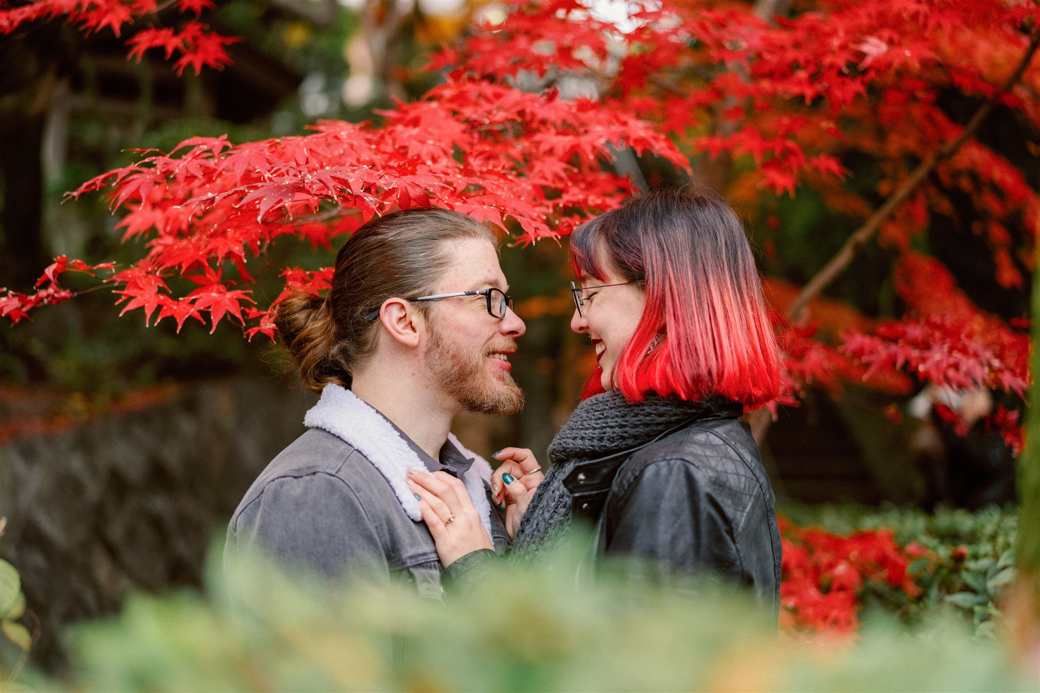 Couple during their autumn elopement with vibrant red foliage. 