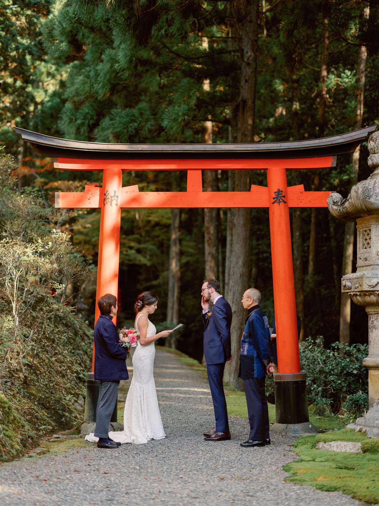 Couple read their vows under a Torii gate during there Japan elopement. 