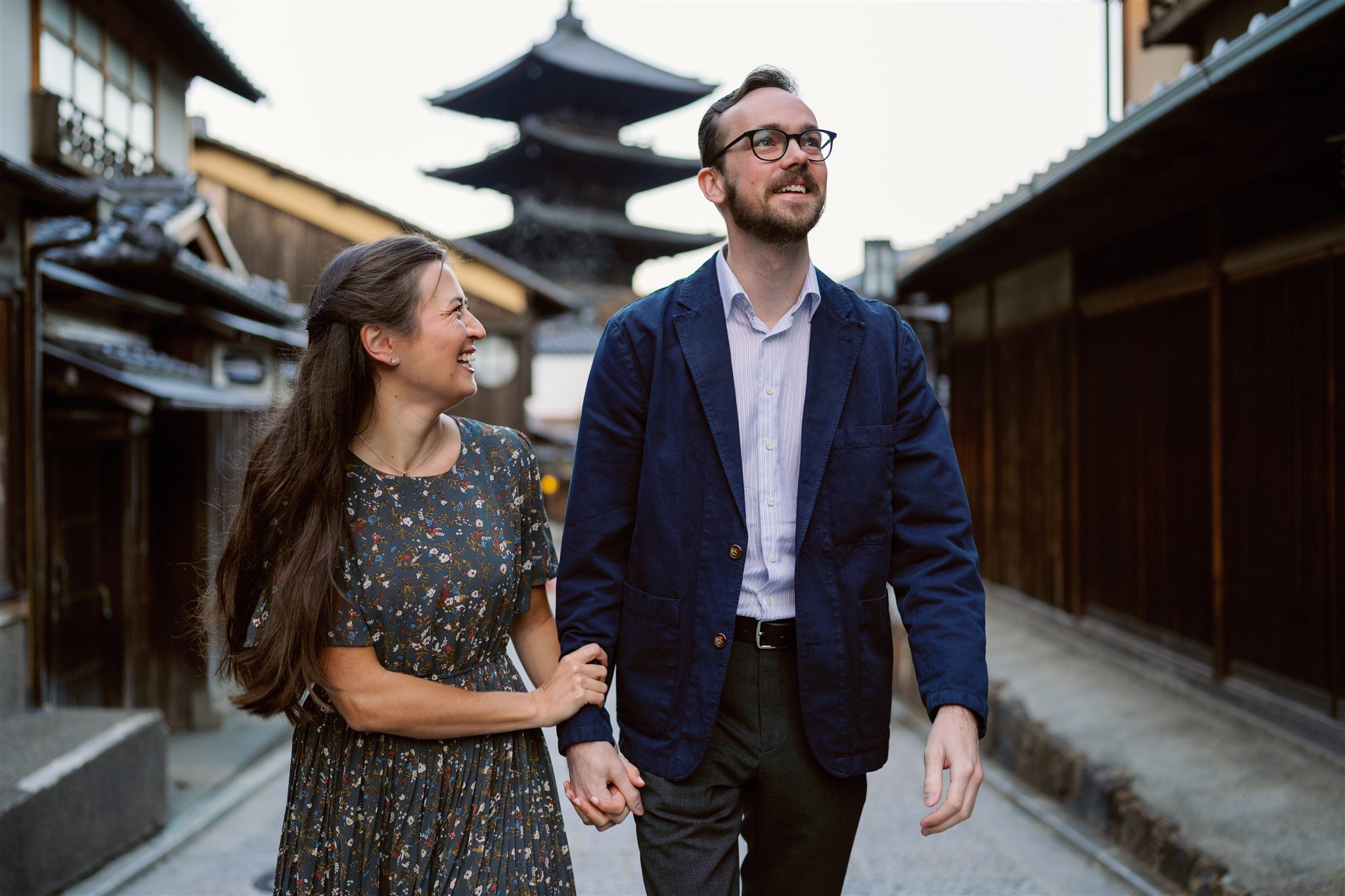 Couple holding hands while strolling through the streets of Kyoto. 