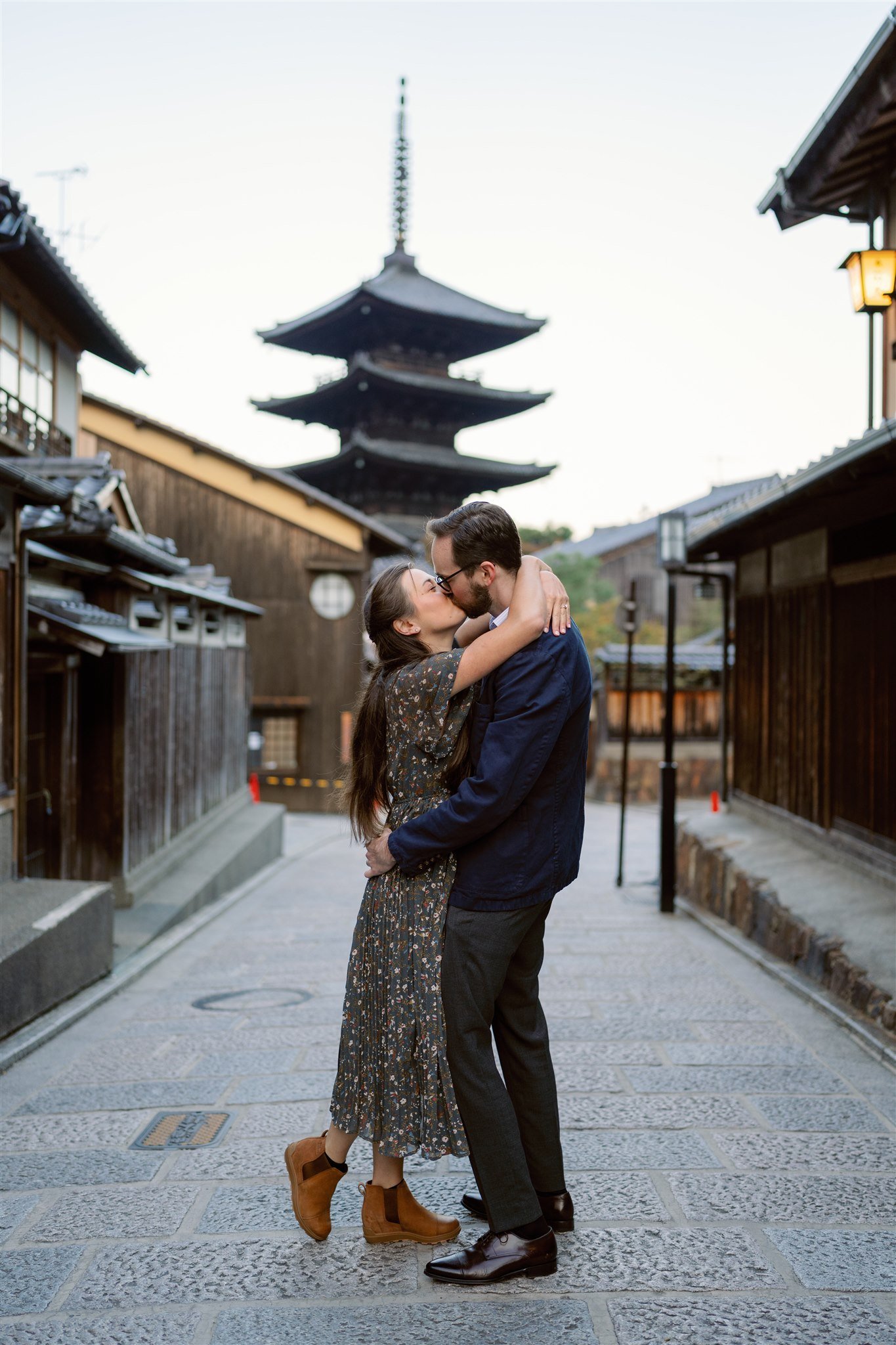 Couple share a kiss in the middle of Kyoto's streets during their engagement photo session. 