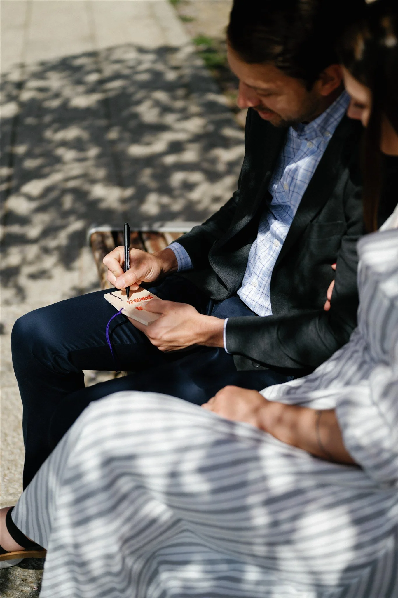 Couple write their wishes on Japanese ema. 
